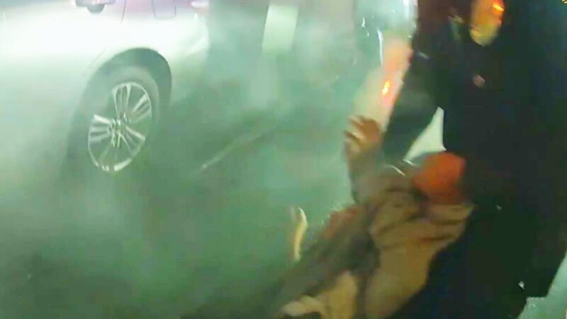 炎上する車から14歳ドライバーが警官によって引っ張り出される。
